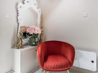 a red chair sitting next to a vase of flowers at Three Chapel Court in Cockermouth