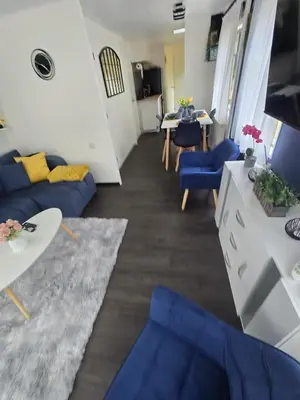 a living room with a blue couch and a table at Woodlands Retreat Holiday Home in Ballantrae