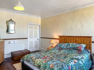 a bedroom with a bed and a dresser and a mirror at Midtown House in Aspatria