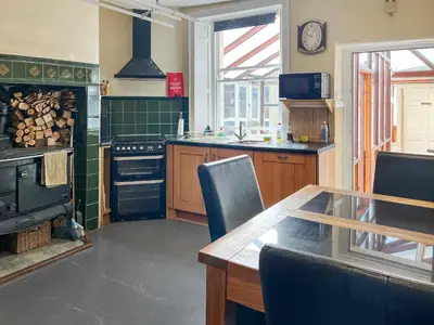 a kitchen with a table and a stove top oven at Midtown House in Aspatria