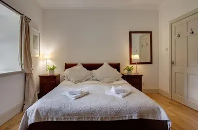 a bedroom with a large bed with two towels on it at Mid Lodge, Penninghame Estate in Challoch