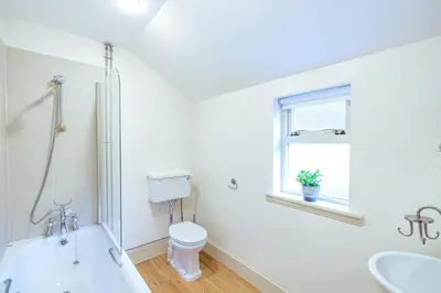 a white bathroom with a toilet and a sink at Mid Lodge, Penninghame Estate in Challoch