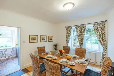 a dining room with a wooden table and chairs at Penninghame Estate - West Lodge in Challoch