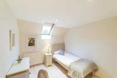 a small bedroom with a bed and a skylight at Penninghame Estate - Wallace Apartment in Challoch