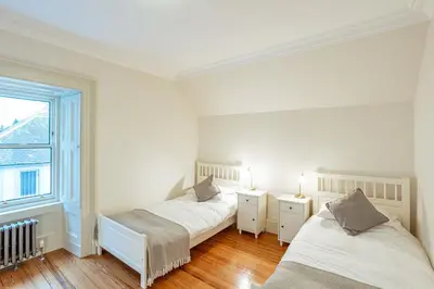two beds in a white room with a window at Penninghame Estate - Stewart Apartment in Challoch