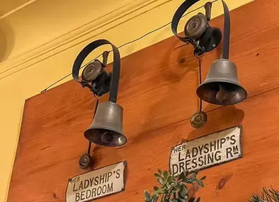 two lights hanging on a wall with a sign at Knockinaam Lodge in Portpatrick
