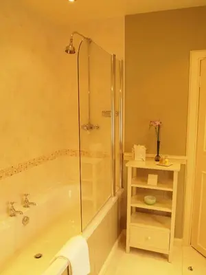 a bathroom with a shower and a tub and a sink at Knockinaam Lodge in Portpatrick