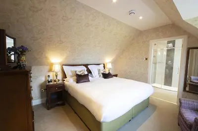 a bedroom with a large white bed and a window at Knockinaam Lodge in Portpatrick