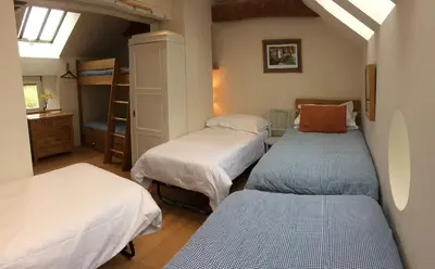 a bedroom with three beds and a bunk bed at The Coach House at Durhamhill with llamas & games room mini cinema in Kirkpatrick Durham
