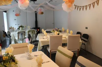 a dining room with white tables and chairs and decorations at The Coach House at Durhamhill with llamas & games room mini cinema in Kirkpatrick Durham