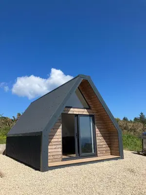 a small cabin with a black roof at Tiny home on an organic croft, Isle of Arran in Kildonan