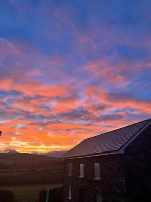a building with a sunset in the sky at Ballavelt in Isle of Man