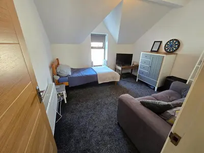 a small room with a bed and a couch at Central Portrush Townhouse available for Open Golf in Moffat