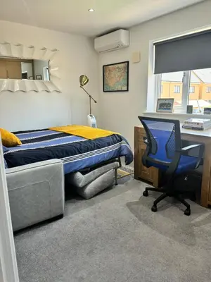 a bedroom with a bed and a desk and a chair at Middle Kent Lux! in Moffat