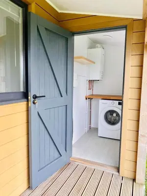 a door to a laundry room with a washing machine at Newly built luxury cabin in Moffat