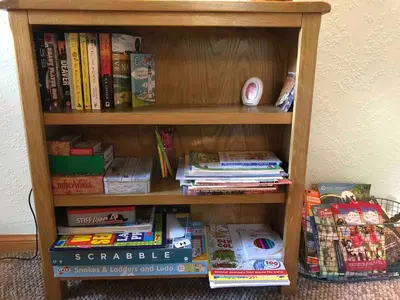 a book shelf filled with books and other books at Corlae Cottage, mountain and forest views in Carsphairn