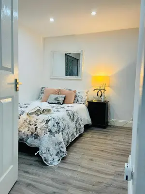 a bedroom with a bed and a mirror on the wall at Hertford detached home garden pet friendly parking in Moffat