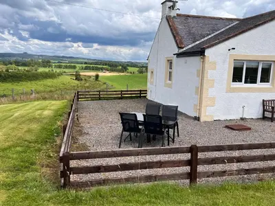 a table and chairs in front of a house at Williamsfield Cottage in Holywood