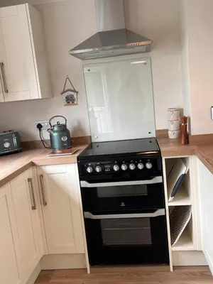 a kitchen with a black stove and a microwave at Williamsfield Cottage in Holywood
