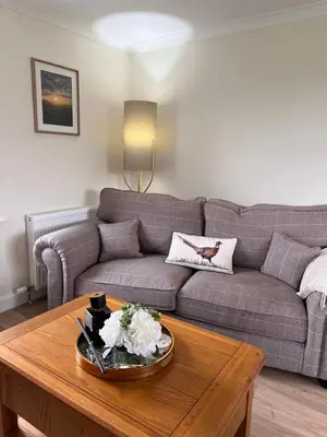 a living room with a couch and a coffee table at Williamsfield Cottage in Holywood
