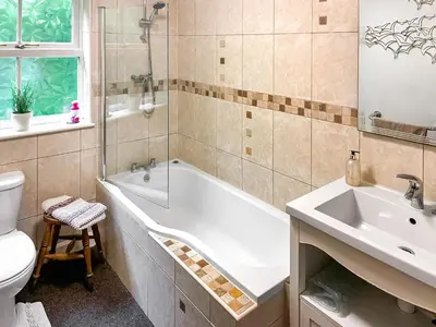 a bathroom with a tub and a toilet and a sink at Professors Cottage in Girvan