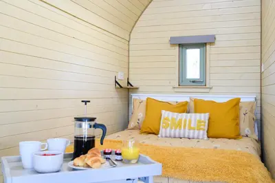 a room with a bed and a table with food on it at Barnharrow Holiday Pods - Rose Glamping Pod with Hot Tub & Fire Pit in Balminnoch