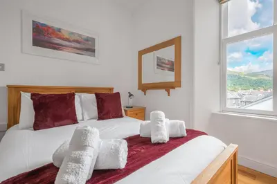 a bedroom with a bed with towels on it at Chaucer Apartment in Keswick