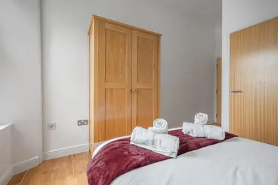 a bedroom with a bed with two towels on it at Chaucer Apartment in Keswick