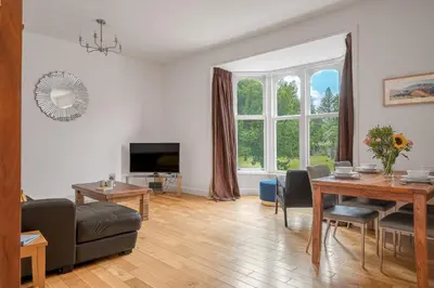a living room with a table and a couch at Chaucer Apartment in Keswick