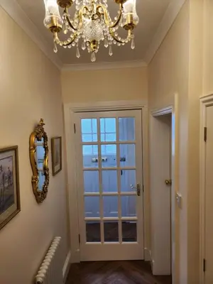 a chandelier in a room with a door with a window at The Troon Hoose in Troon