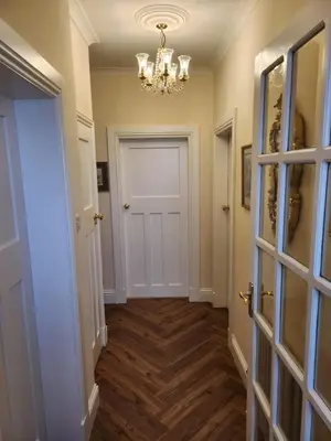 a hallway with a door and a chandelier at The Troon Hoose in Troon