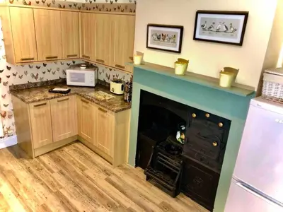 a kitchen with a fireplace in the middle of it at The MireHouse - Georgian rural retreat in Ullock