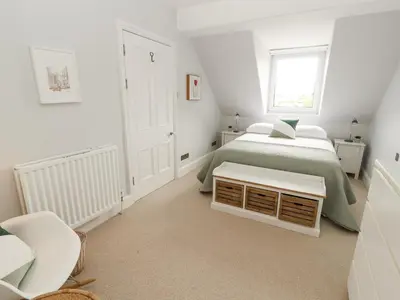 a white bedroom with a bed and a window at 43 Station Road in Keswick