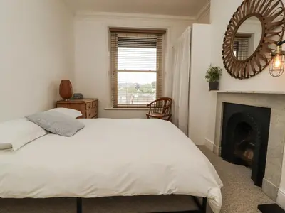 a bedroom with a white bed and a fireplace at 43 Station Road in Keswick