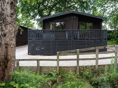 a wooden cabin with a fence in front of it at Watendlath in Keswick