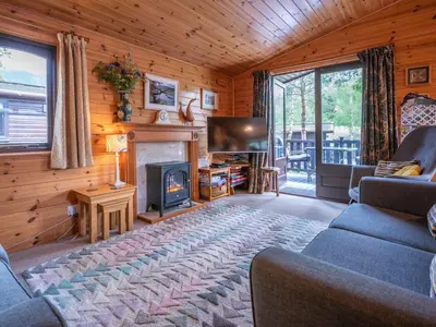 a living room with a fireplace and a tv at Watendlath in Keswick