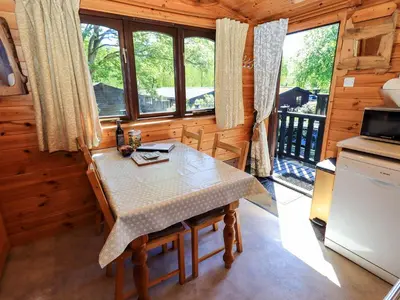 a dining room with a table and some windows at Watendlath in Keswick