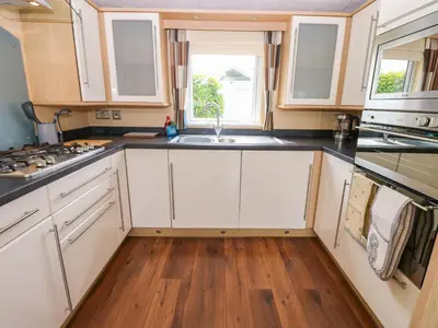 a kitchen with white cabinets and a sink at 12 Field View in Carlisle