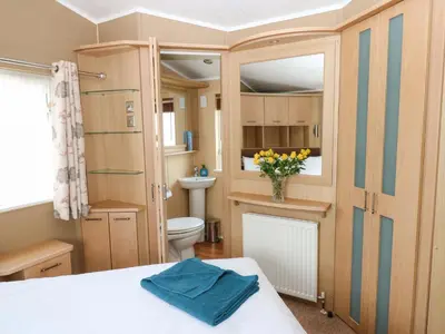 a small bathroom with a toilet and a vase of flowers at 12 Field View in Carlisle