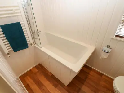 a white bathroom with a tub and a toilet at 12 Field View in Carlisle
