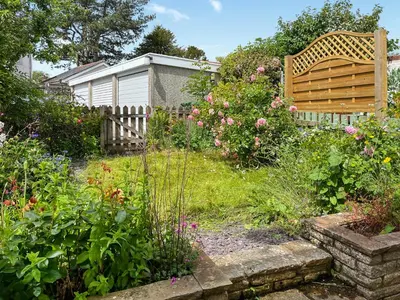 a garden with a wooden bench and some flowers at Rubby Banks Retreat in Cockermouth