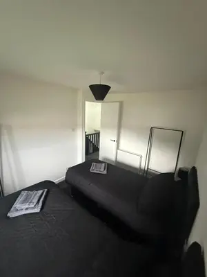 a bedroom with two beds and a black blanket at Home Comfort Prestwick in Prestwick