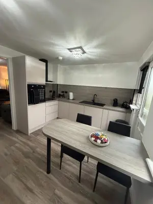 a kitchen with a table with a bowl of fruit on it at Home Comfort Prestwick in Prestwick