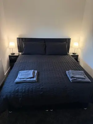 a bedroom with a bed with two towels on it at Home Comfort Prestwick in Prestwick