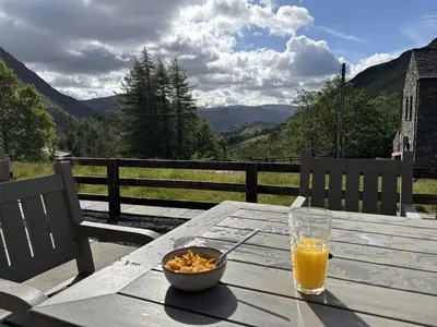 a table with a bowl of cereal and a glass of orange juice at Swirral Edge Cottage in Penrith