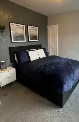 a bedroom with a large bed with a blue comforter at HULL 2BED Sleeps 4 BETTO Cosy Home! in Moffat