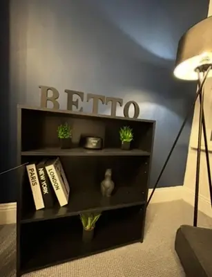 a black book shelf with books and plants on it at HULL 2BED Sleeps 4 BETTO Cosy Home! in Moffat