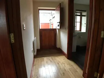 a hallway with a wooden door and a window at Castlehead Cottage in Keswick