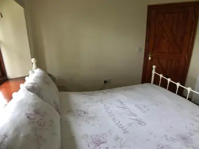 a bed with a white comforter and pillows at Castlehead Cottage in Keswick