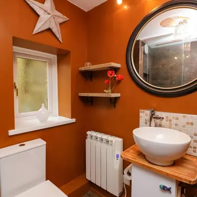 a bathroom with a white sink and a mirror at Tranquil Lake District Village Apartment in St Bees